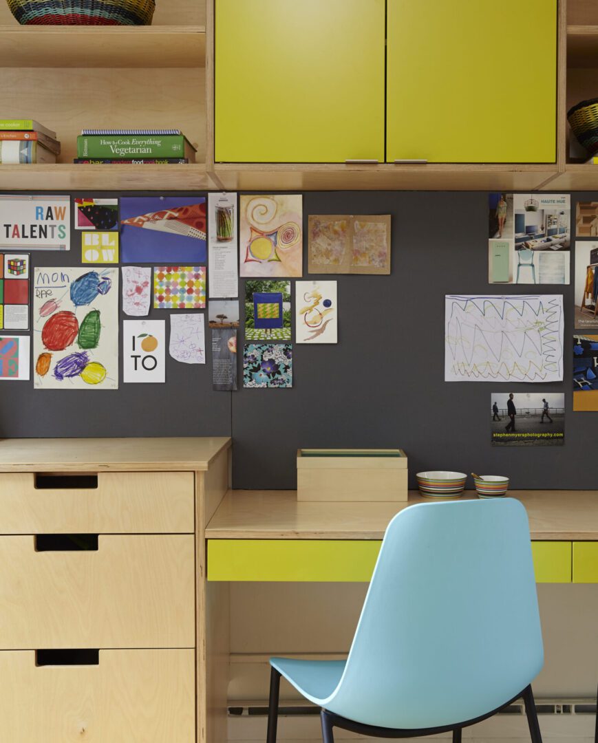 A child's room with a yellow desk and blue chair.