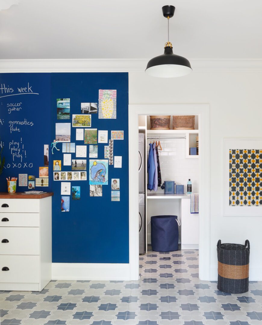 A room with a blue wall and white cabinets.