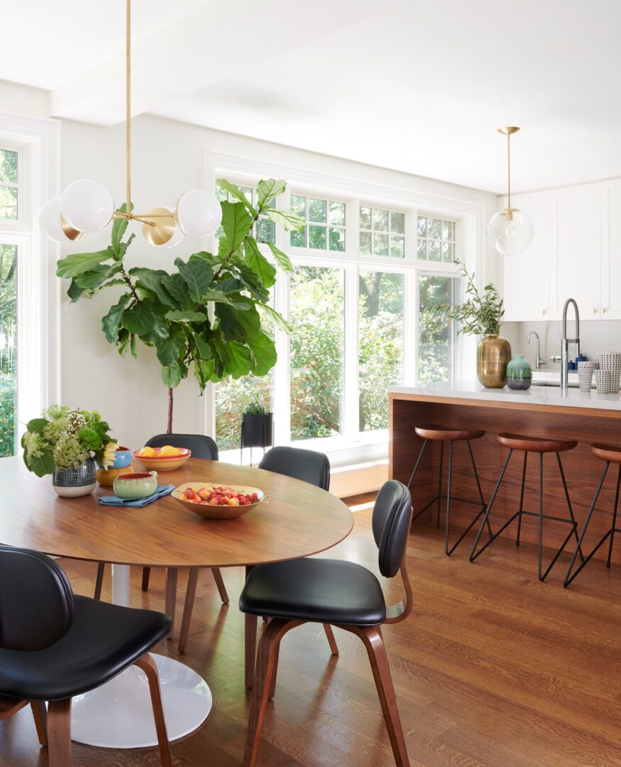 A dining room table with chairs and a plant in the middle of it.